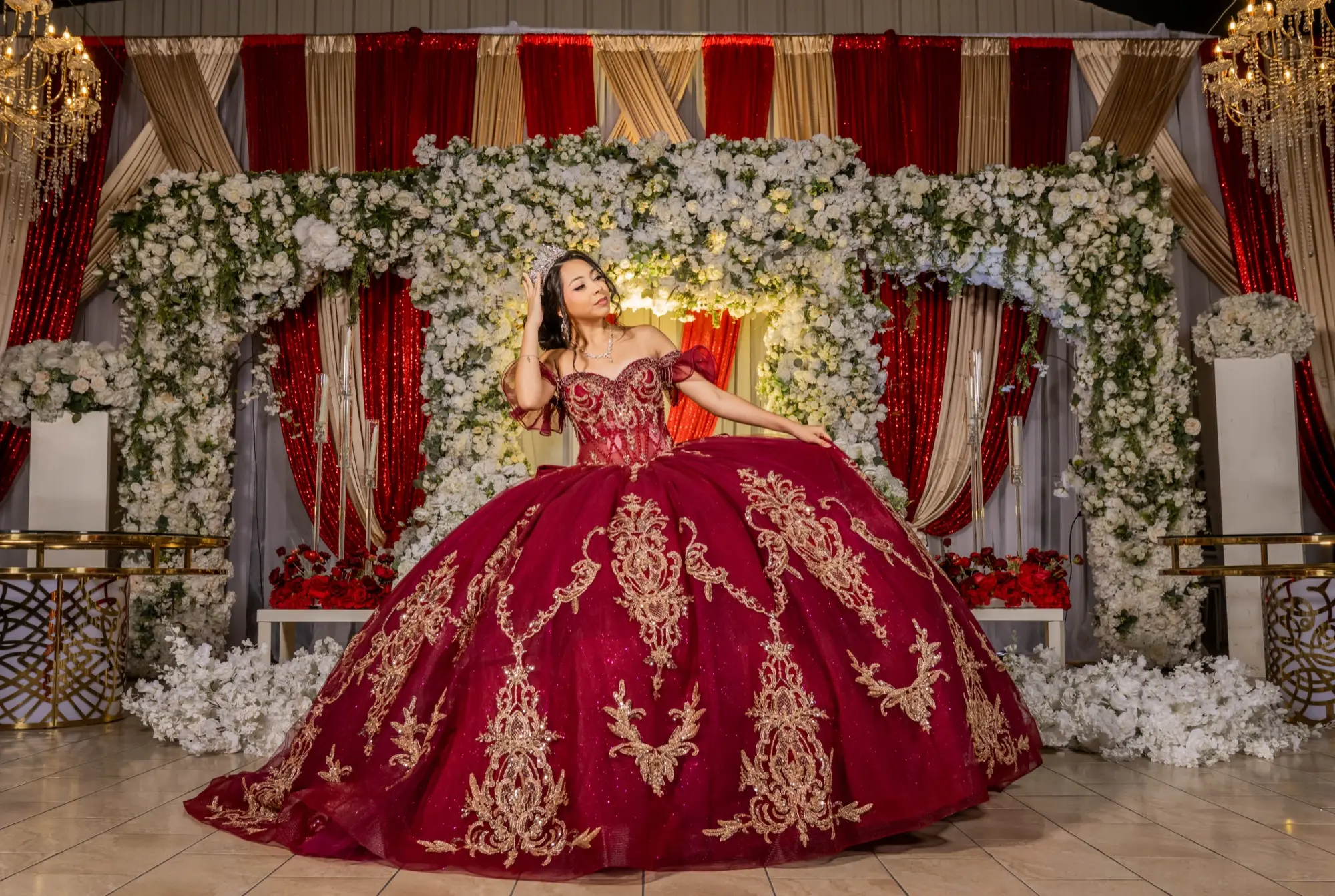 Quinceañera in a burgundy ball gown on a throne