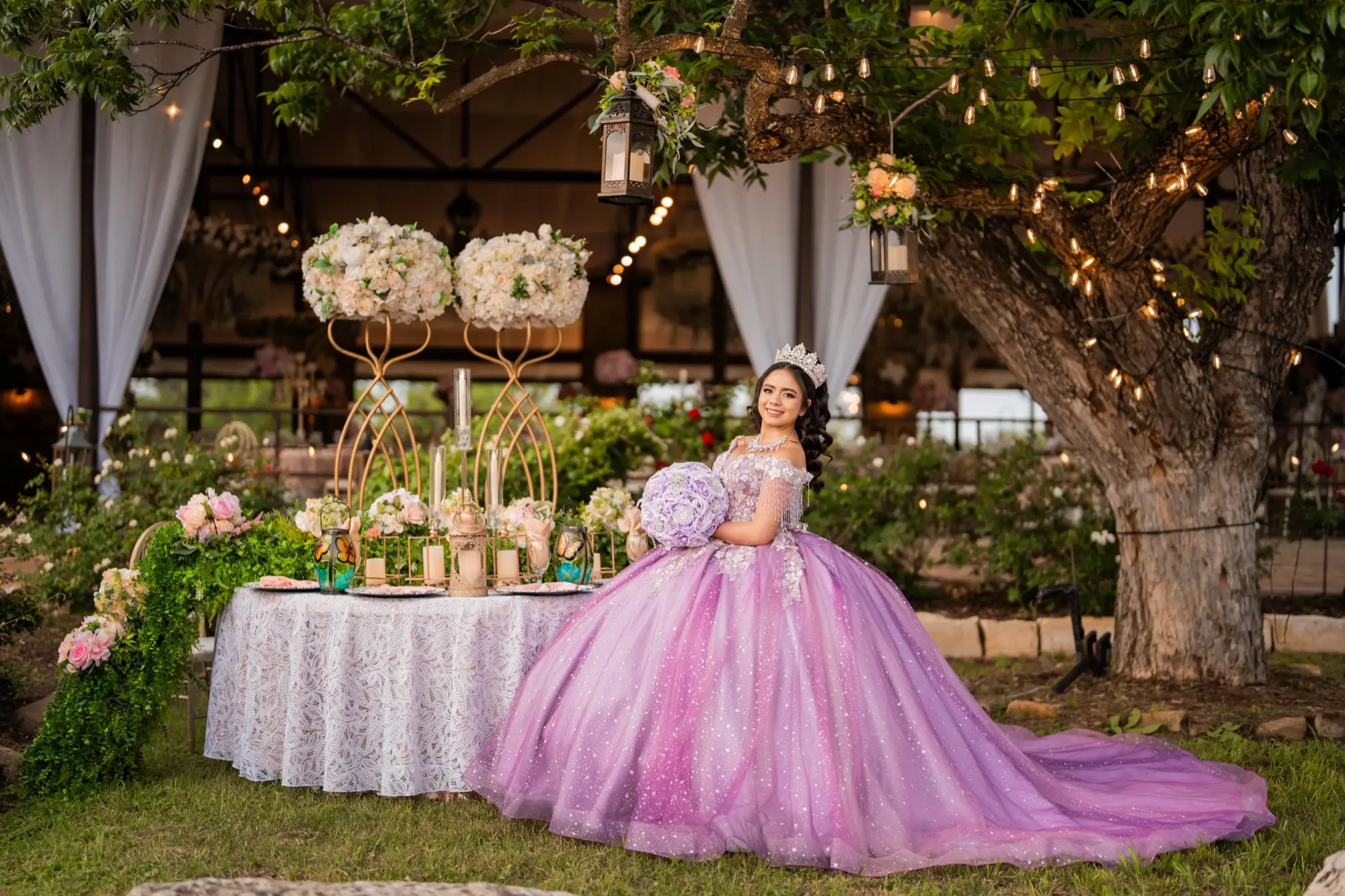 Quinceañera in a lilac gown beside a decorated table