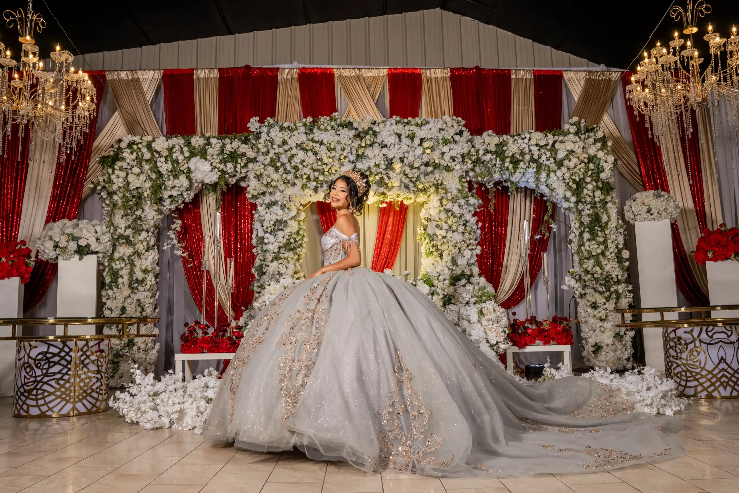 Quinceañera in a silver ball gown on a throne